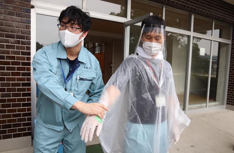避難所での受付担当者は感染症対策のため防護服を着用