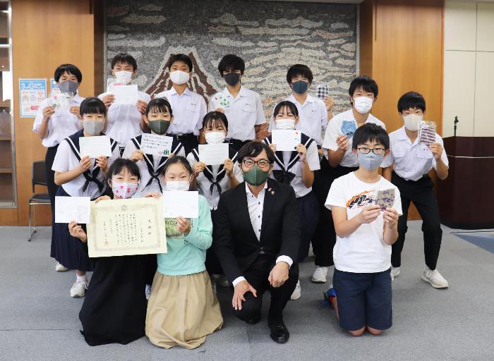 市長(中央)と感謝状を手にする学習塾「LeTS赤池校」の生徒