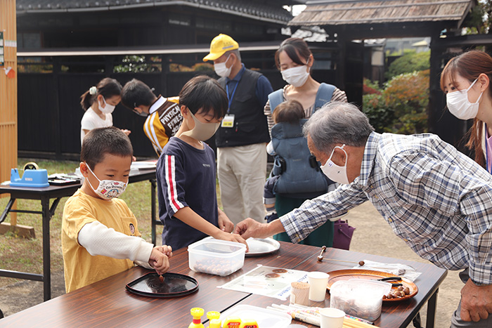 ドングリでこまを作る子どもたち