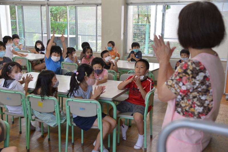 寄付者へ感謝を込めて拍手をする児童たち