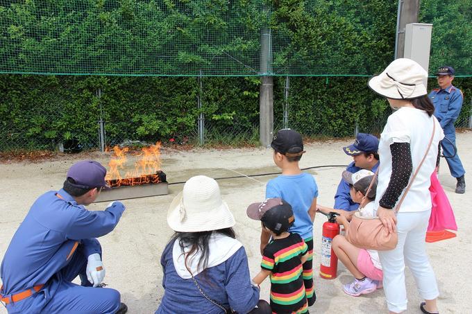 消防団の活動中、地域総合防災訓練で消火器の取り扱いについての説明を聞く参加者の写真