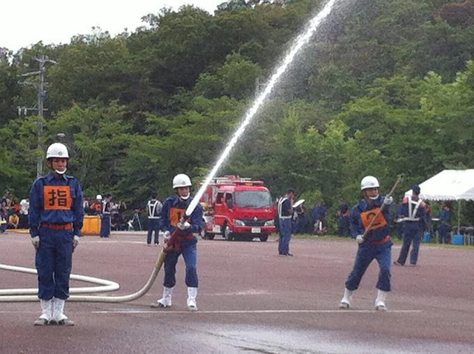 ホースから水をだし、消防操法の訓練をしている様子の写真