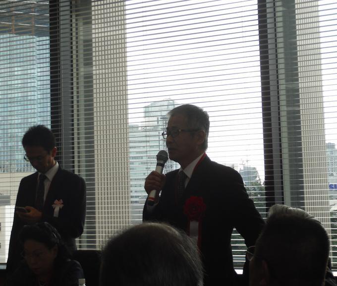 懇談会でマイクを持ち発表する鈴木さんの写真