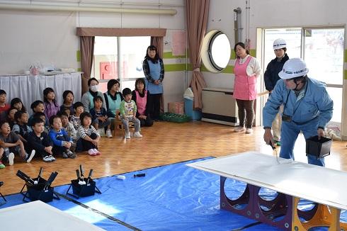 現場監督より指導を聞いている園児と先生方の様子の写真