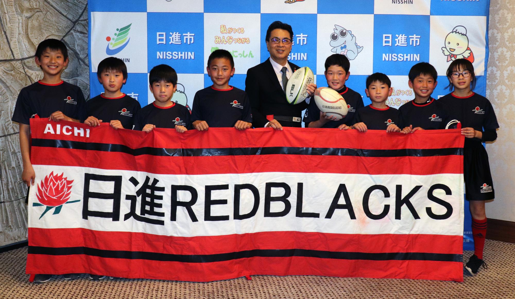 表敬訪問した日進レッドブラックスの選手の皆さんと記念撮影をする近藤市長