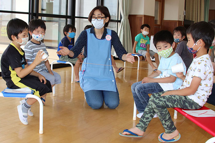 糸電話を用いてソーシャルディスタンスについて学ぶ園児たち