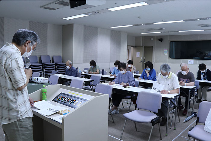 作家のヘミングウェイについて説明する講師と熱心に聞き入る受講者