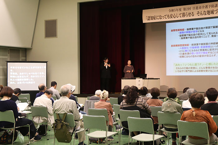 認知症について説明をする講師と耳を傾ける参加者らの様子