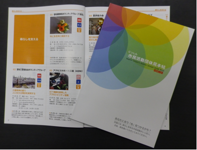赤から青への円がグラデーションに配置された表紙と開いて置かれた見本帳の写真