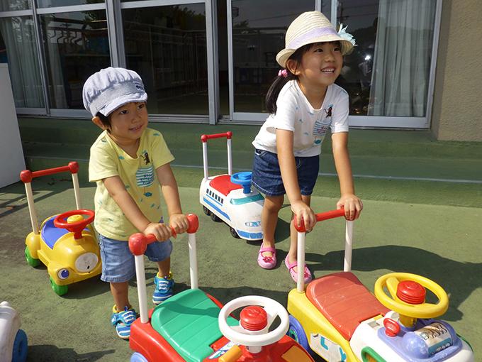 手押し車で遊ぶ幼児たちの写真