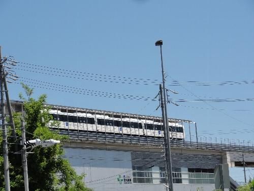 芸大通駅に停車しているリニモを見上げた写真