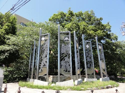 古戦場公園のモニュメント、透かし彫りのパネルに家紋が入ったものが円形に並んでいる写真