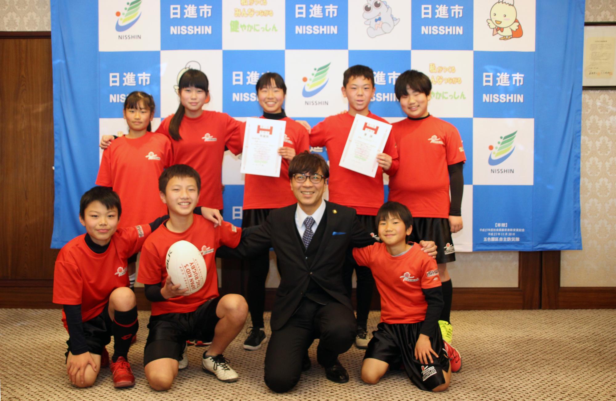 タグラグビーの皆さんと写真を撮る近藤市長