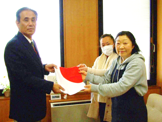 有限会社マルフクより香久山小学校と梨の木小学校へ国旗を寄贈している様子の写真