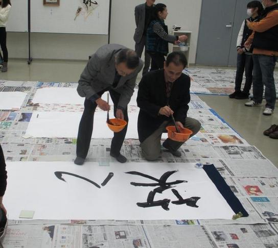 男性2名が書き初めをしている様子の写真