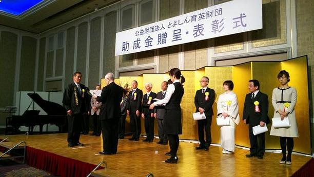 とよしん育英財団による助成・表彰者の表彰式にて表彰を受けているひとの写真