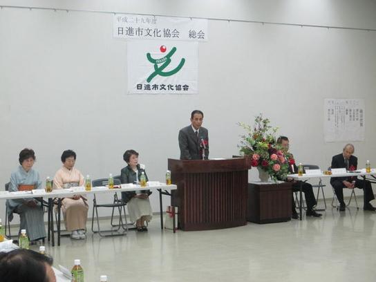 日進市文化協会の総会にて話しをしている人の横で話を聞いている人たちの写真