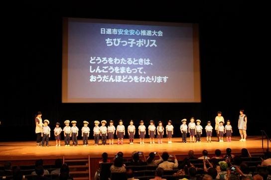 日進市安全安心推進大会にてプロジェクターの前で子供たちが並んで立っている様子の写真