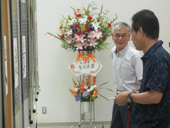 男性2名が花の前で話をしている様子の写真