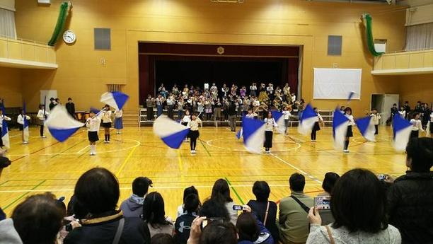 体育館でフラッグをふっている複数名が写っている写真