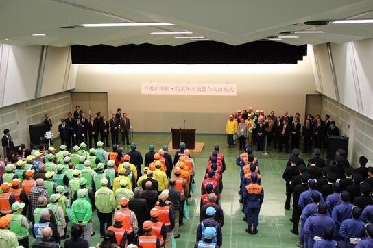 日進市民会館にて平成29年日進市防犯・防災年末夜警合同出発式が開催され参加者が整列している写真