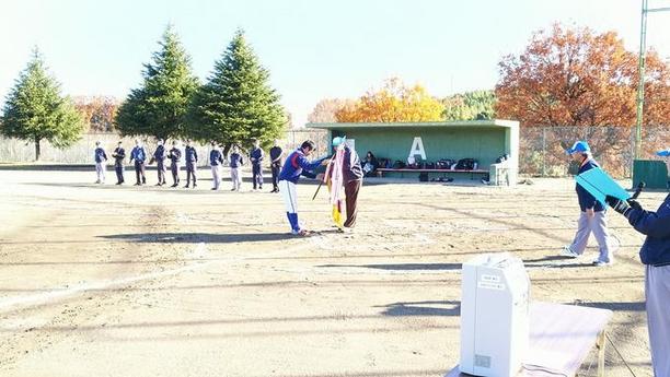 口論義運動公園にて第34回愛日軟式野球大会が開催され旗を渡している様子の写真