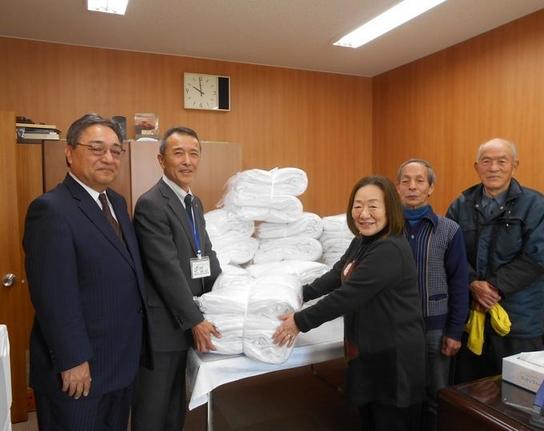 寄贈されたタオルを真ん中にしている集合写真