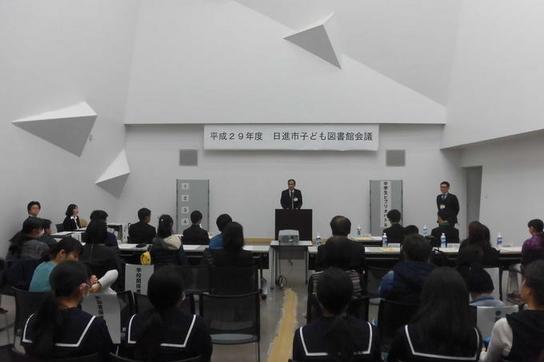 「日進市子ども図書館会議中学生ビブリオバトル」にて参加者の前であいさつをしている写真