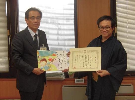 市内を中心に活動されている「劇団三文芝居」代表の柳澤二郎さんより紙芝居の寄贈の様子の写真