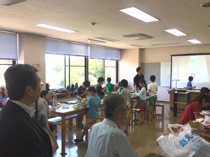 日進市民会館にて行われた少年少女発明クラブの活動を見学している男性の写真