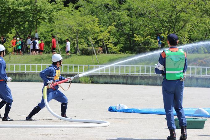 日進市総合運動公園にて第24回日進市消防操法大会が開催された際のホースをもって放水している様子の写真