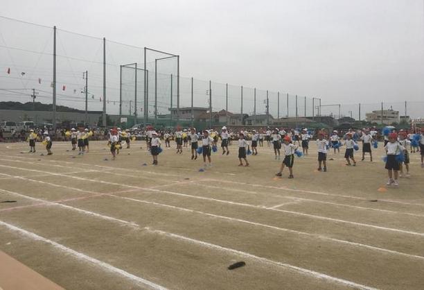 運動場でポンポンをもって踊っている男女生徒の写真