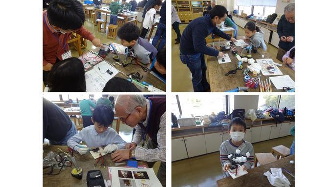 発明クラブ4年生Bクラスの子供たちが、豆電球とLEDを流れる電流を測定し違いについて学んだあとLEDの花作り体験をしている写真