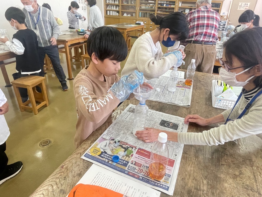 漏斗を使って、オルトケイ酸ナトリウムをペットボトルに入れる様子