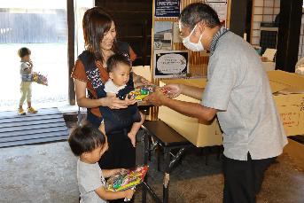 旧市川家住宅入り口で子どもがお菓子を貰っている写真1