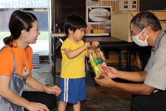 旧市川家住宅入り口で子どもがお菓子を貰っている写真3