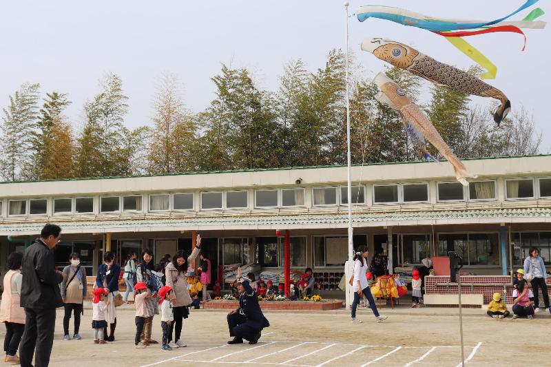 こいのぼりが泳ぐ園庭で、横断歩道の渡り方を学ぶ園児たち