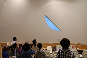 学習室の月形の窓を見上げる参加者たち