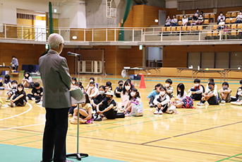 開講式で指導員の話を聞く子どもたち