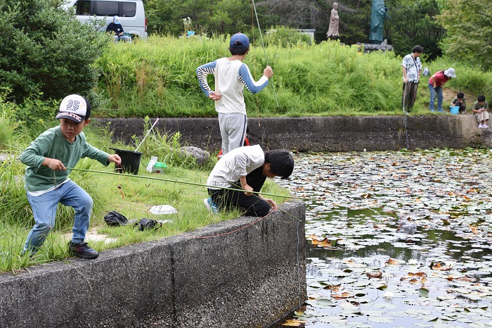 池の周りで釣りをしている人たちの写真