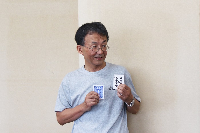 2枚のトランプのカードを持つ男性の写真