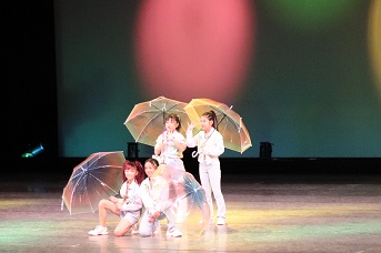 傘を持ってポーズをとる子どもたちの写真