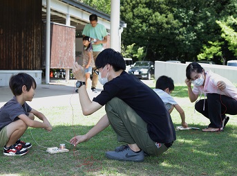 屋外でラジオを聴く親子の写真