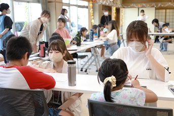 学生が子どもと対面で座っている写真