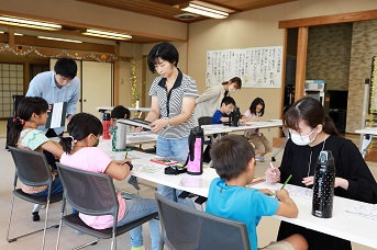 学生が子どもたちと一緒に作業をしている写真