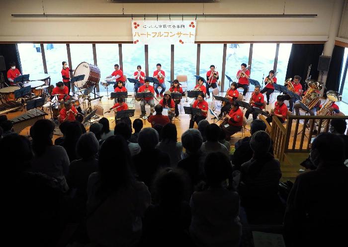 日進市民吹奏楽団が演奏する姿を満員の客席の後側から撮影した写真
