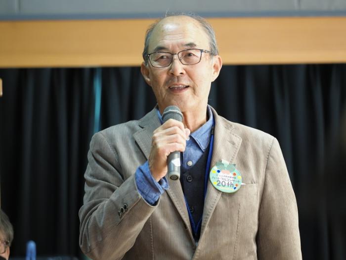 共催したにっしん水晶山市民の会の田中理事長があいさつをしている写真