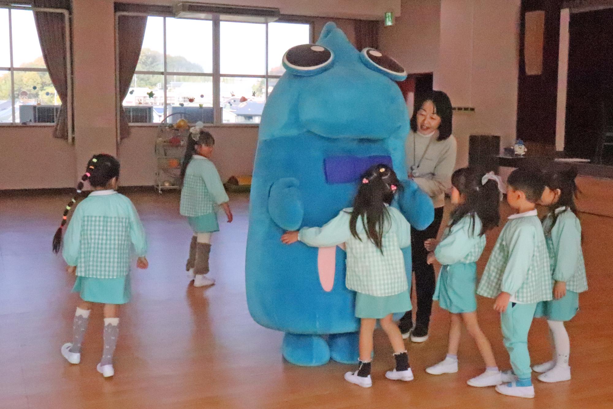 ニッシーとハグをするこどもたちの写真