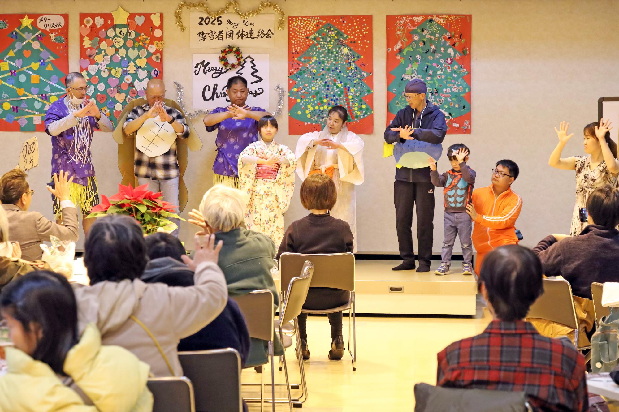 ステージ上でうらしまたろうの手話劇を行う様子の写真