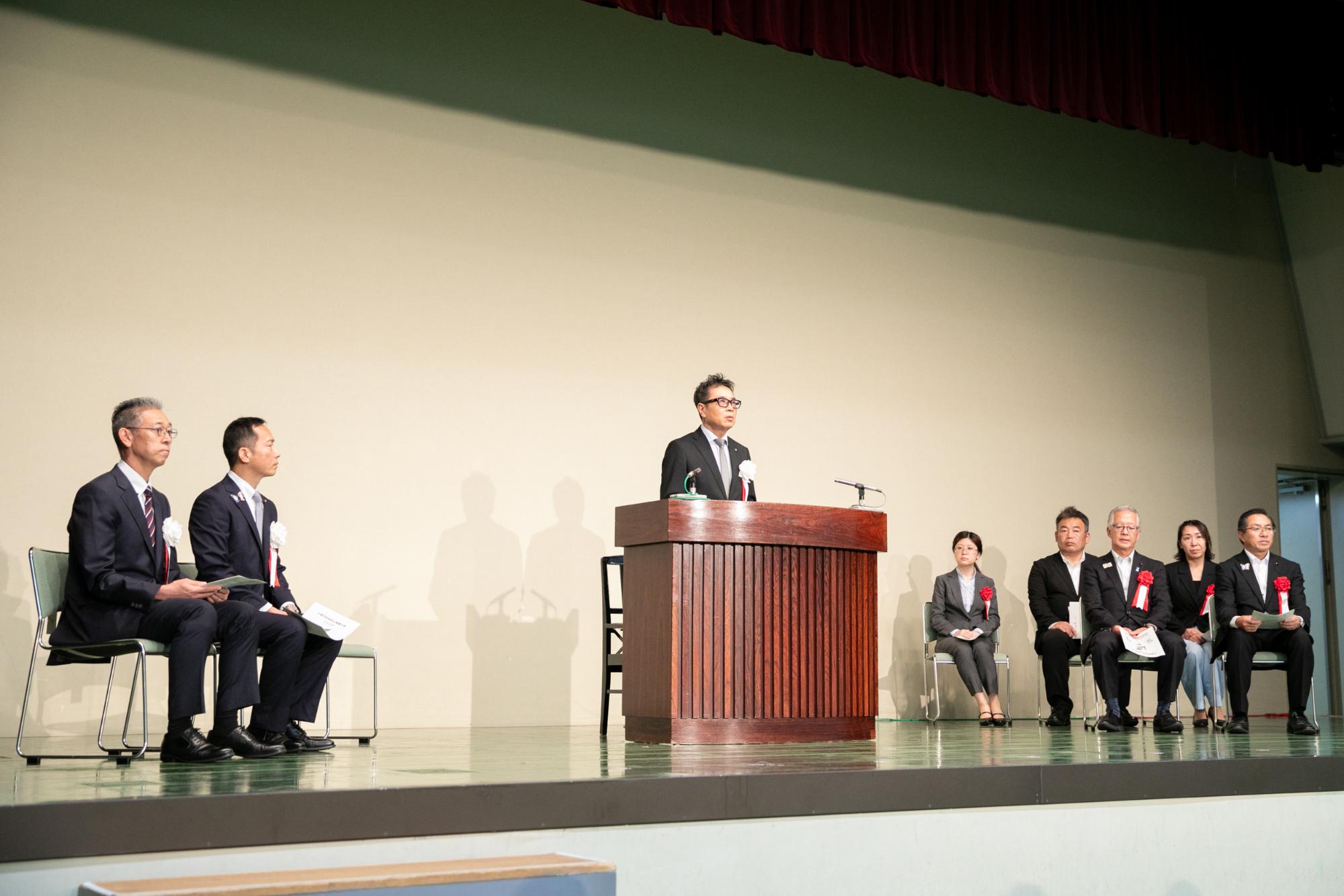 市長が壇上であいさつを行う様子の写真